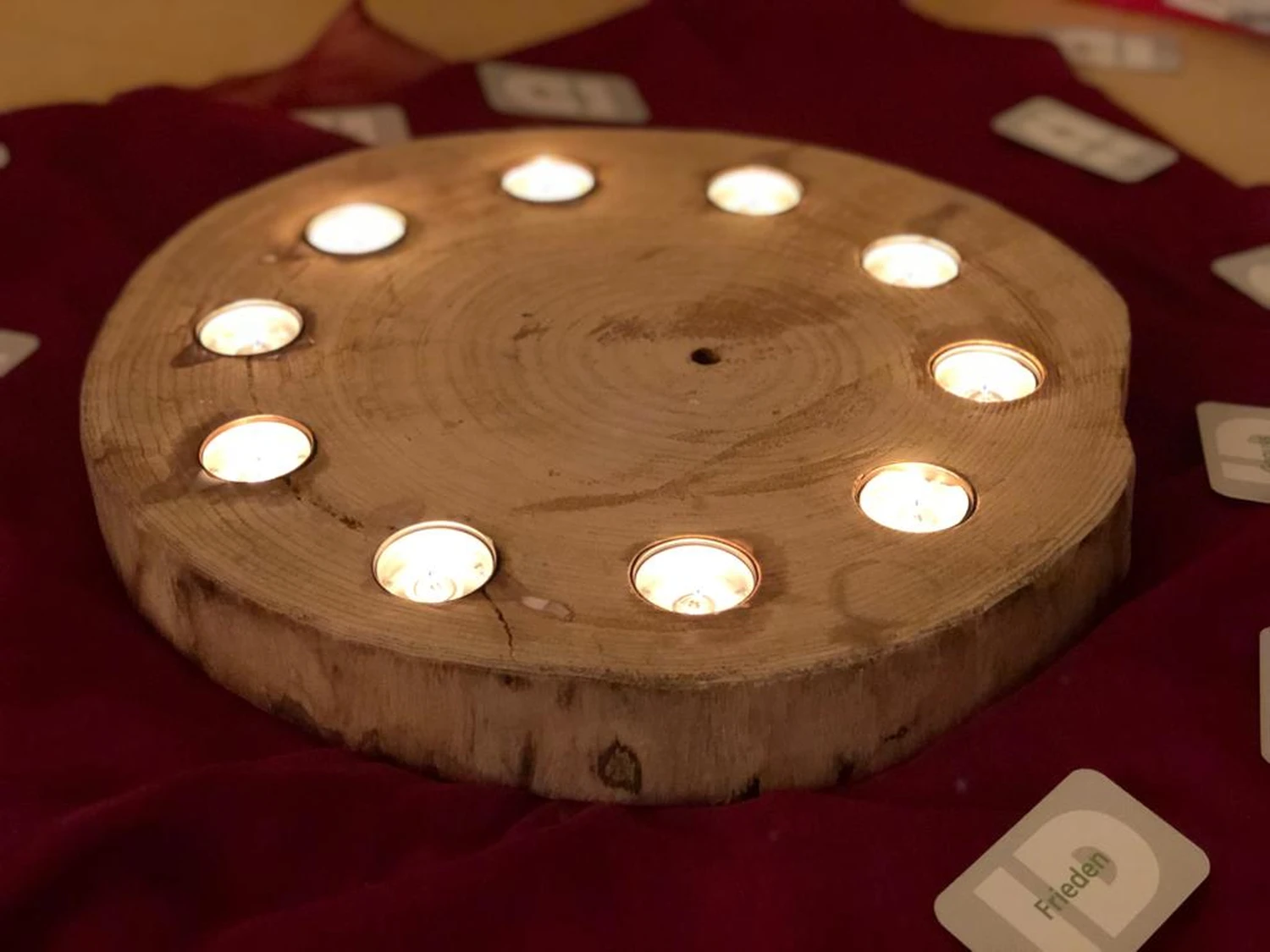 Hebamme Trauma-Fachberaterin - Coaching, Beratung, Kurse und Lesungen - Ein rustikaler Adventskerzenhalter aus Holz, gefertigt aus einer Baumscheibe, der oft als Tischdekoration verwendet wird.